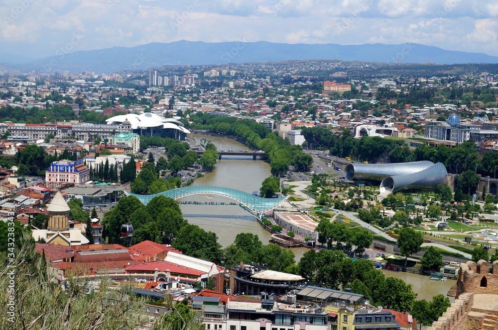 Tbilisi, Georgia. Kura River. Top view of the city. Glass Bridge of Peace over the Kura River. Park Rike. House of Justice