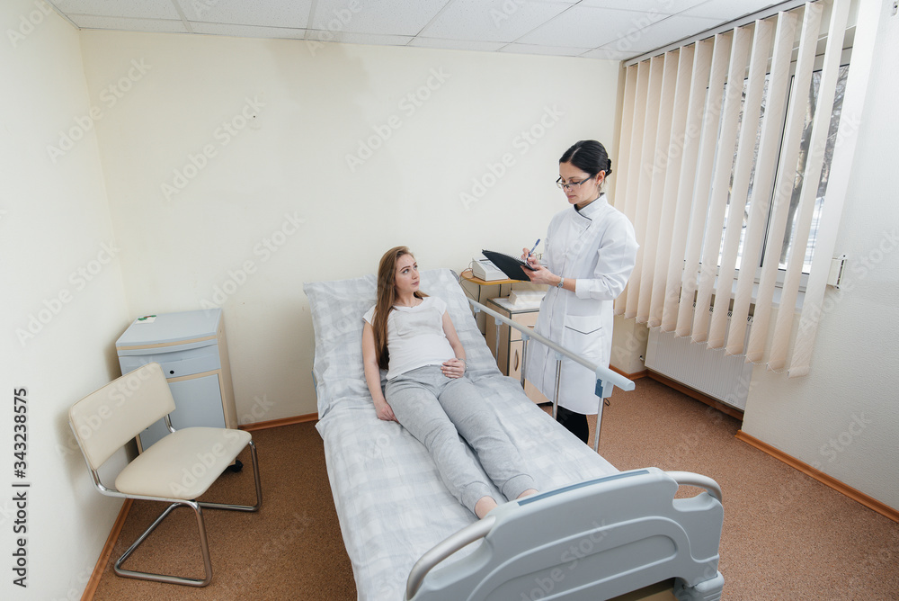 The doctor advises and serves a young pregnant girl in a medical clinic. Medical examination The doctor advises and serves a young pregnant girl in a medical clinic. Medical examination