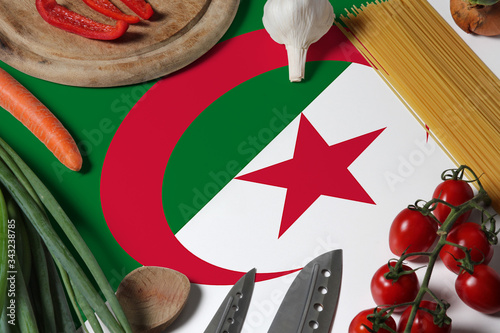 Algeria flag on fresh vegetables and knife concept wooden table. Cooking concept with preparing background theme.