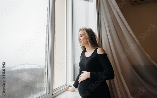 Free Download A pregnant girl is breathing fresh air from the window - GFXLoad