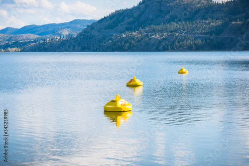 Yellow buoys marking hazardous area with dangerous under currents on lake, where swimming is not permitted