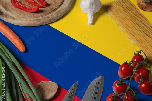 Colombia flag on fresh vegetables and knife concept wooden table. Cooking concept with preparing background theme.