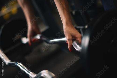 Close up of woman with dumbbells. Young woman in the gym.