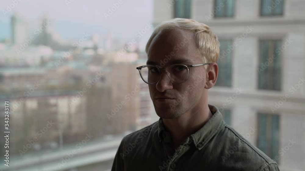 Handsome young business man looks across Los Angeles from Downtown office window. Big close up with sunrise sky, dolly shot originally recorded in 4K Handsome young business man looks across Los Angeles from Downtown office window. Big close up with sunrise sky, dolly shot originally recorded in 4K