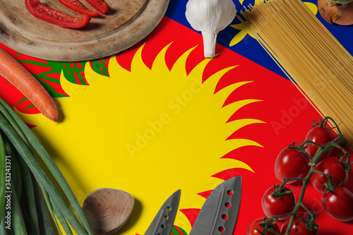Guadeloupe flag on fresh vegetables and knife concept wooden table. Cooking concept with preparing background theme.