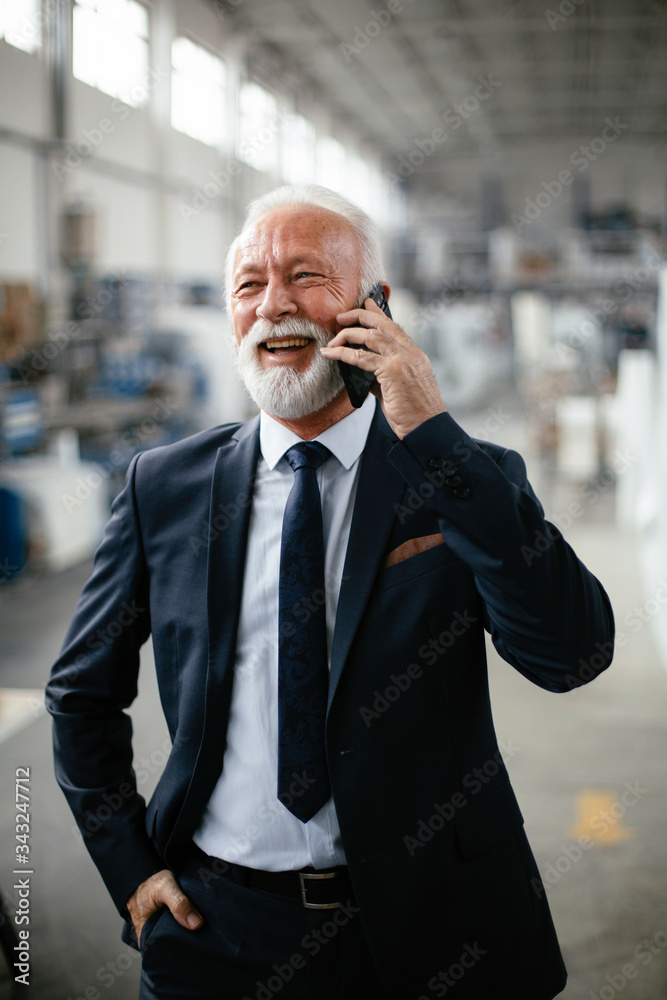 Portrait of handsome businessman talking to the phone. Man working in factory. Portrait of handsome businessman talking to the phone. Man working in factory.