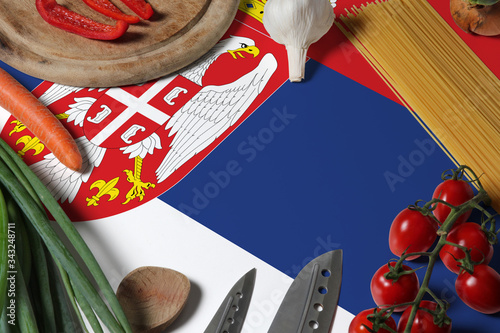 Serbia flag on fresh vegetables and knife concept wooden table. Cooking concept with preparing background theme.