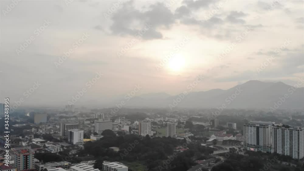 Cloudy and misty view of the city and the mountain with trees - descending