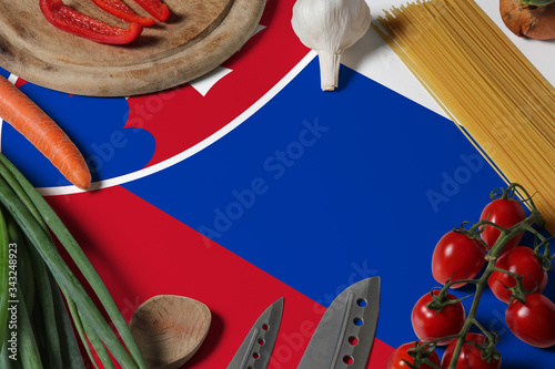 Slovakia flag on fresh vegetables and knife concept wooden table. Cooking concept with preparing background theme.
