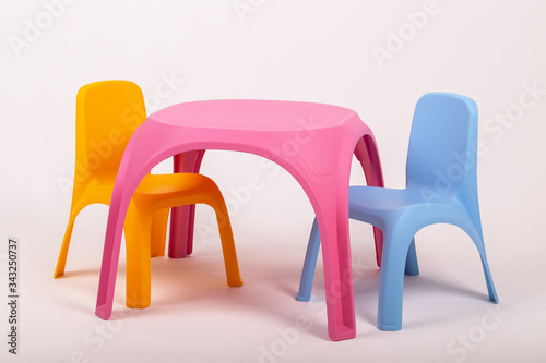 yellow plastic childrens table and two chairs on white background