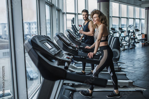 Portrait of young sports couple making cardio workout in modern gym © Тарас Нагирняк