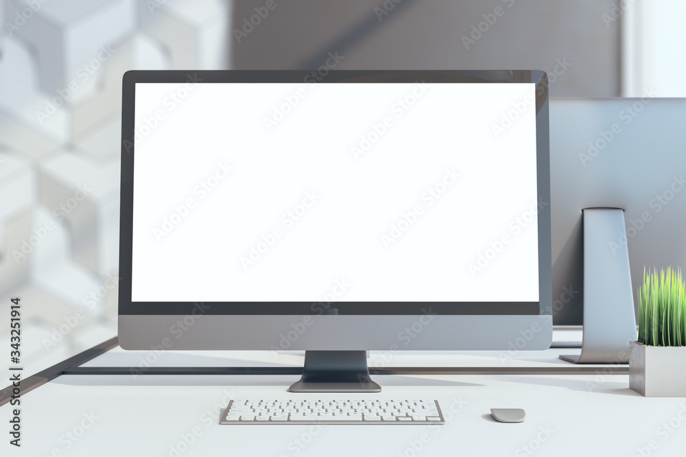 Blank white computer monitor screen on table in office