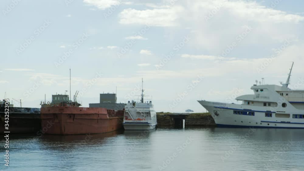 Lockdown: Old and Modern Boats Docked at the Small Pier While the Water Below Reflects the Sky - Lake Baikal, Russia Lockdown: Old and Modern Boats Docked at the Small Pier While the Water Below Reflects the Sky - Lake Baikal, Russia