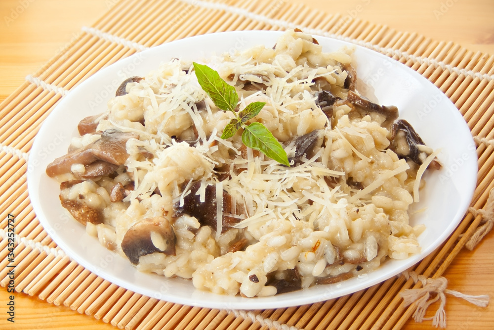 Tasty appetizing risotto on  white plate on  wooden table