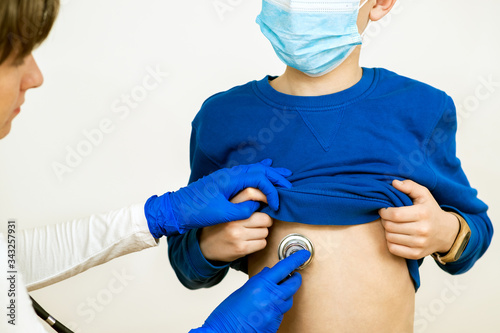 Closeup detail of doctor hand examining ill child with stethoscope.