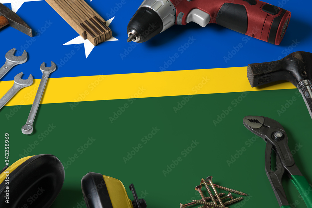 Solomon Islands flag on repair tool concept wooden table background. Mechanical service theme with national objects.