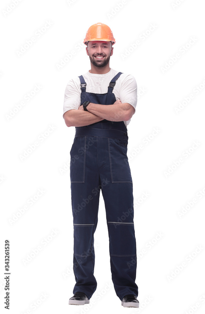 in full growth. smiling man in overalls and a safety helmet in full growth. smiling man in overalls and a safety helmet
