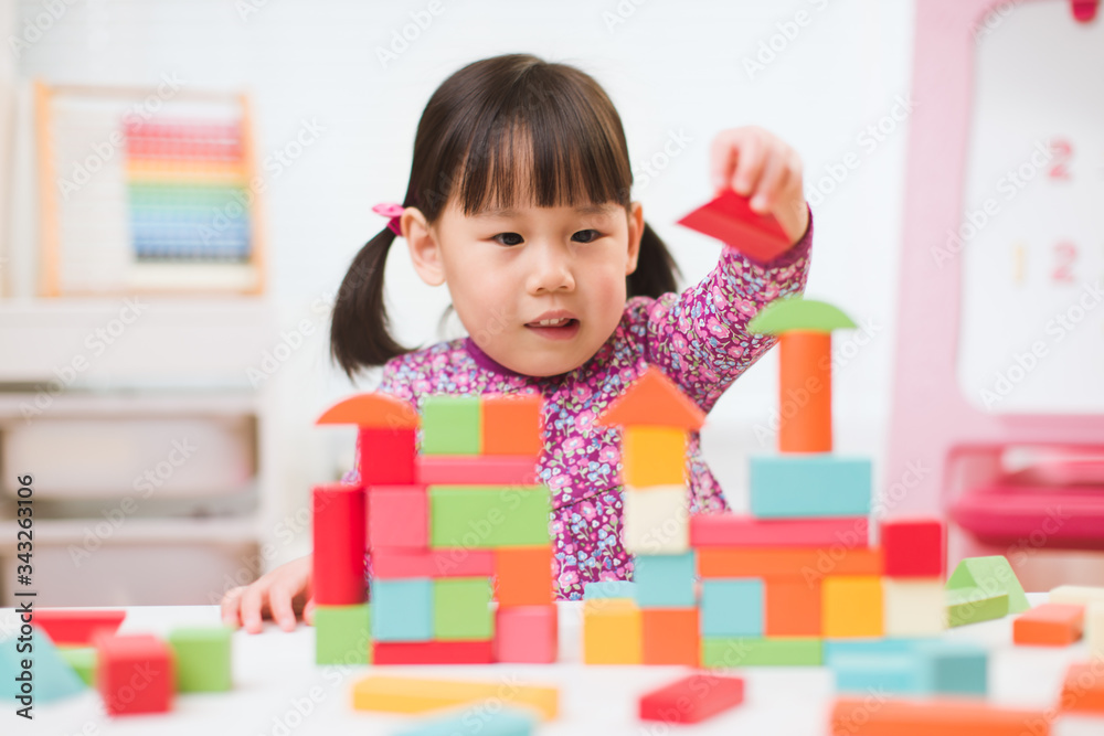 toddler girl playing creative toy blocks at home against white background toddler girl playing creative toy blocks at home against white background