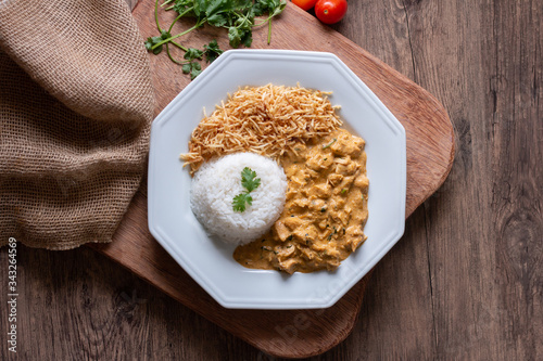 Food plate with meat stroganoff with rice and french fries. Wood background. Flat lay.