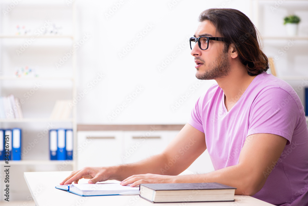 Young male student preparing for exams at classroom Young male student preparing for exams at classroom