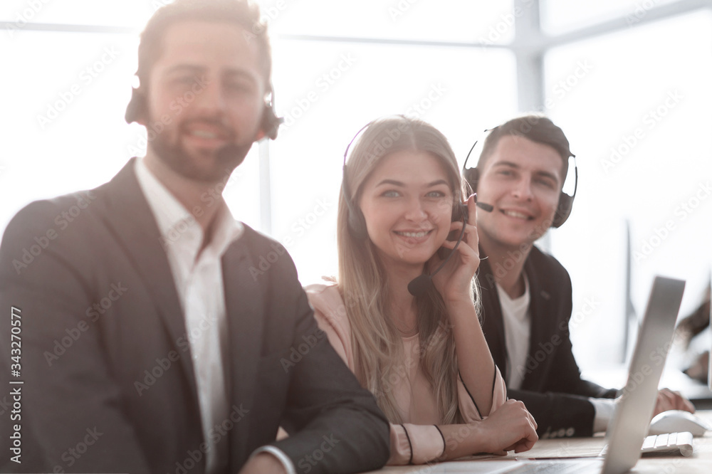 employees in a headset sitting at an office Desk. employees in a headset sitting at an office Desk.