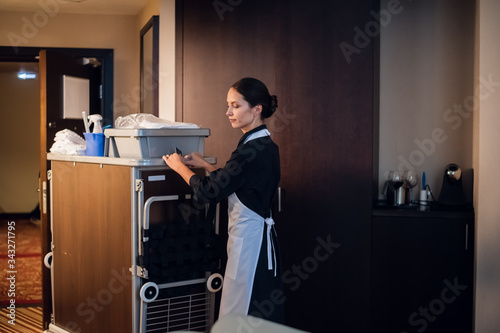 Photos A hotel maid in a uniform cleaning the rooms in a hotel