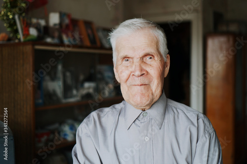 Portrait of senior old 90 years man with gray hair, looking smily in camera.