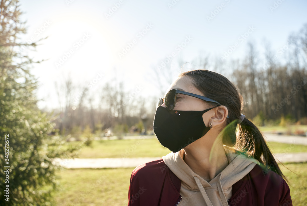 girl protects herself from the coronavirus with a homemade black mask