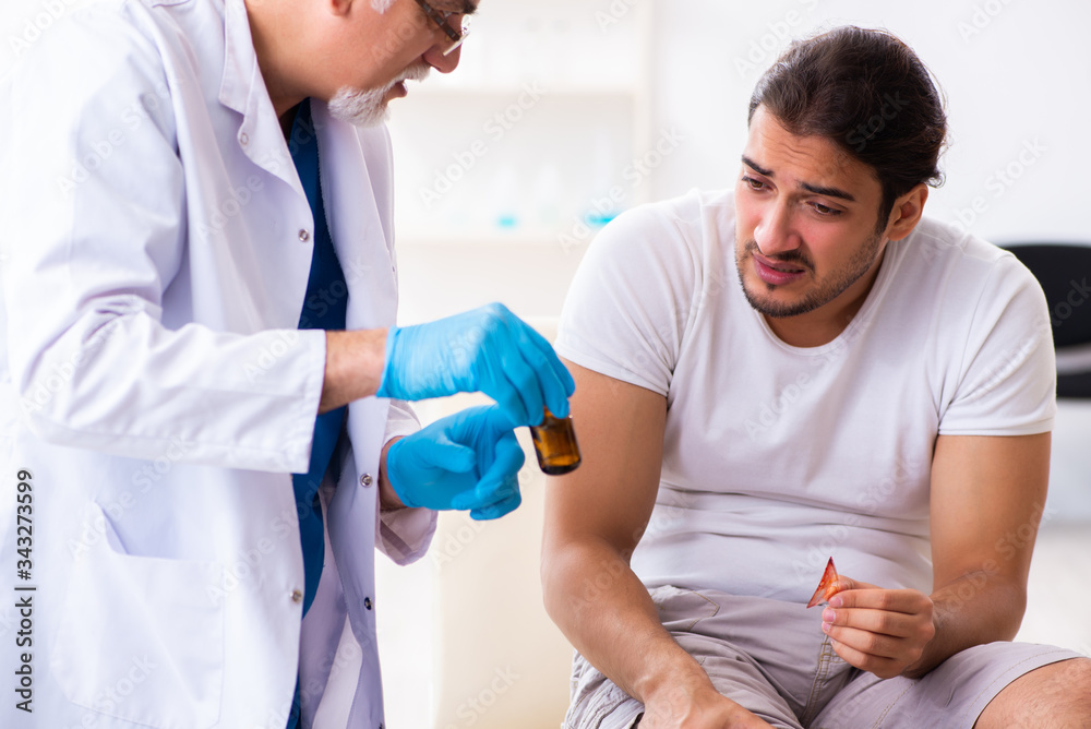 Obraz premium Leg injured man visiting old doctor in first aid concept