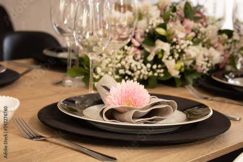 Elegant table setting with flowers and white and black dinnerware