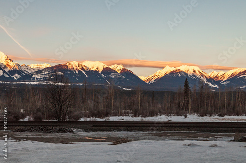 Snow capped mountain and fog at sunrise in british columbia Canada.