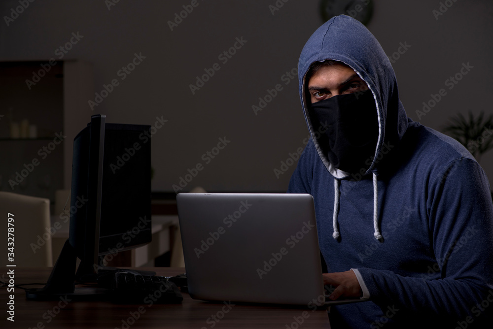 Male hacker hacking security firewall late in office Male hacker hacking security firewall late in office