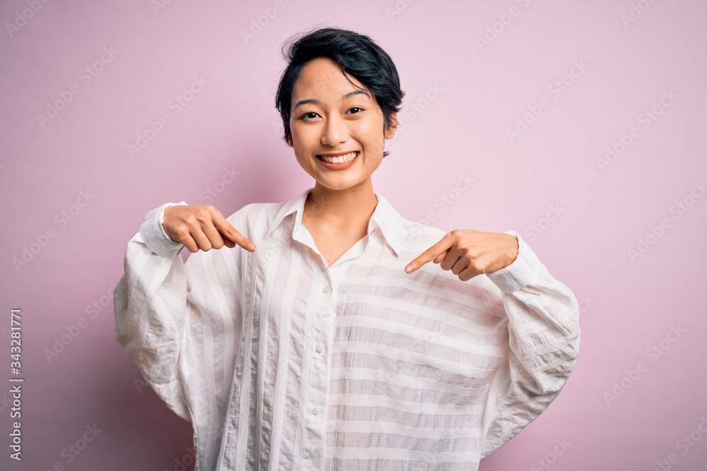 Young beautiful asian girl wearing casual shirt standing over isolated pink background looking confident with smile on face, pointing oneself with fingers proud and happy. Young beautiful asian girl wearing casual shirt standing over isolated pink background looking confident with smile on face, pointing oneself with fingers proud and happy.
