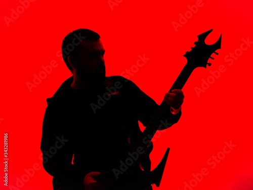 Heavy guitarist with a spiked guitar, odd shapes, with a horned headstock, on colorful background