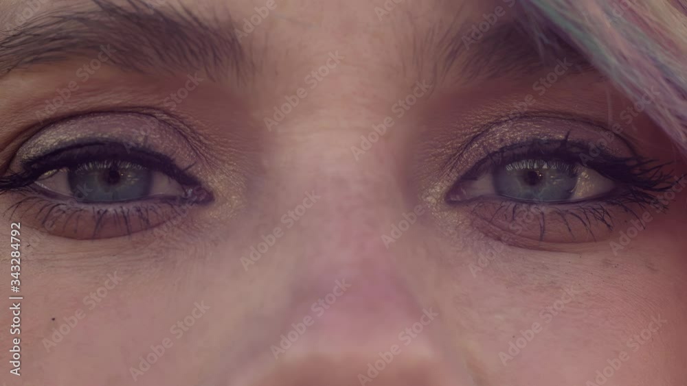 Closeup of woman blinks blue eyes and watches in different paths. She is looking in camera, then up, to the right, to the left and down. Then she stares ahead. Closeup of woman blinks blue eyes and watches in different paths. She is looking in camera, then up, to the right, to the left and down. Then she stares ahead.