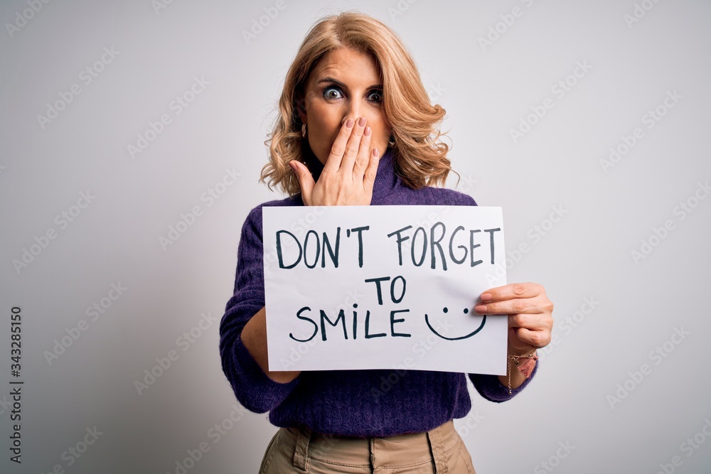Middle age beautiful blonde woman holding banner funny positive message cover mouth with hand shocked with shame for mistake, expression of fear, scared in silence, secret concept Middle age beautiful blonde woman holding banner funny positive message cover mouth with hand shocked with shame for mistake, expression of fear, scared in silence, secret concept