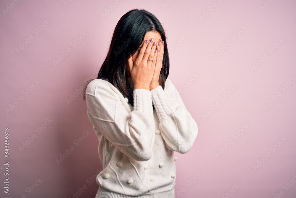 Young brunette woman with blue eyes wearing casual sweater over isolated pink background with sad expression covering face with hands while crying. Depression concept. Young brunette woman with blue eyes wearing casual sweater over isolated pink background with sad expression covering face with hands while crying. Depression concept.