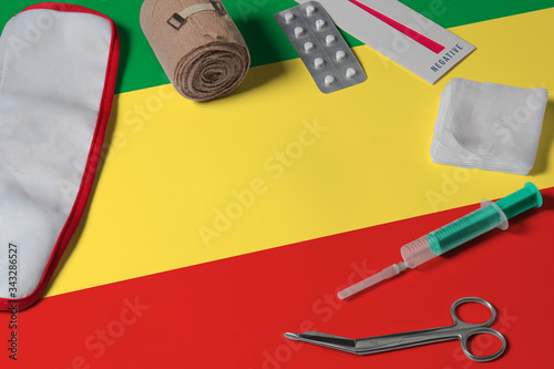 Republic Of The Congo flag with first aid medical kit on wooden table background. National healthcare system concept, medical theme.