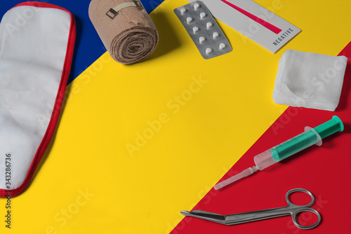 Romania flag with first aid medical kit on wooden table background. National healthcare system concept, medical theme.
