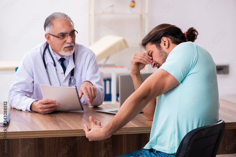 Injured young man visiting old doctor Injured young man visiting old doctor