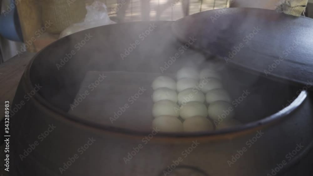 Homemade red bean bun, sold in Nami Island, South Korea, steamed in an old iron stove, medium track right in slow motion.