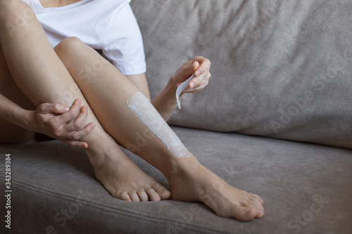 Home legs depilation. Faceless woman makes herself depilation of legs with cream © Oksana