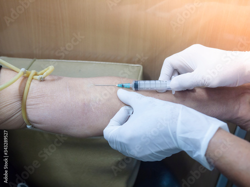 Health and Medical concept. Hands nurse are using needle to pierce vein Preparation for blood test on table. The procedure use needle of Blood collection from the patient's arm for blood analysis.