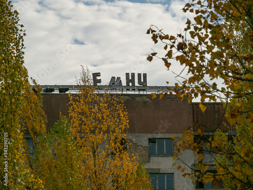 Canvas Print Decaying residential building with a part of signpost in russian language