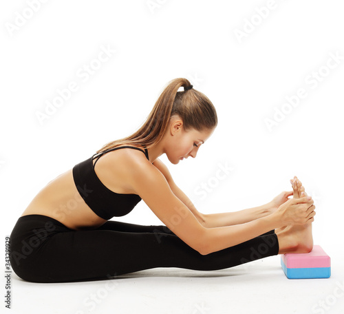 young woman practicing yoga using yoga blocks