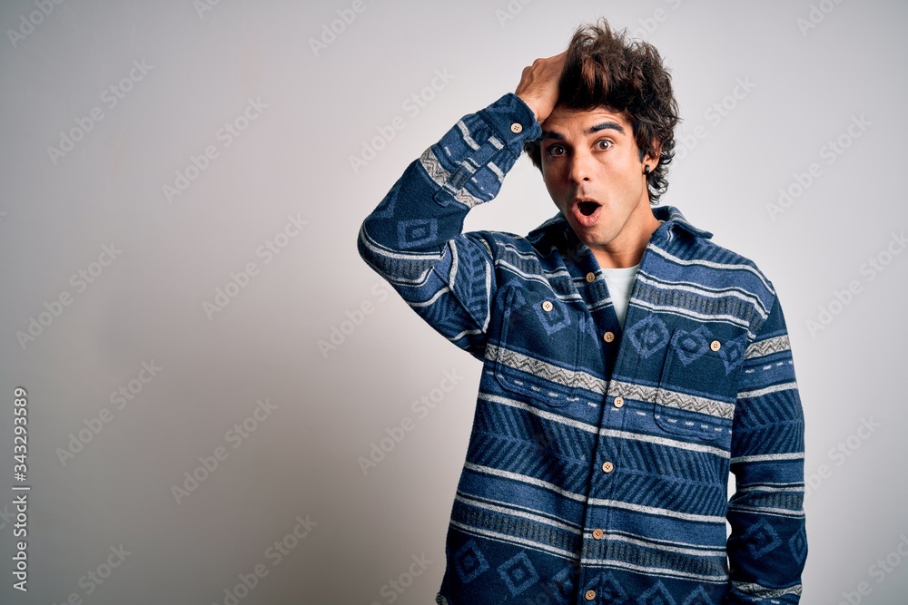 Young handsome man wearing casual shirt standing over isolated white background surprised with hand on head for mistake, remember error. Forgot, bad memory concept.