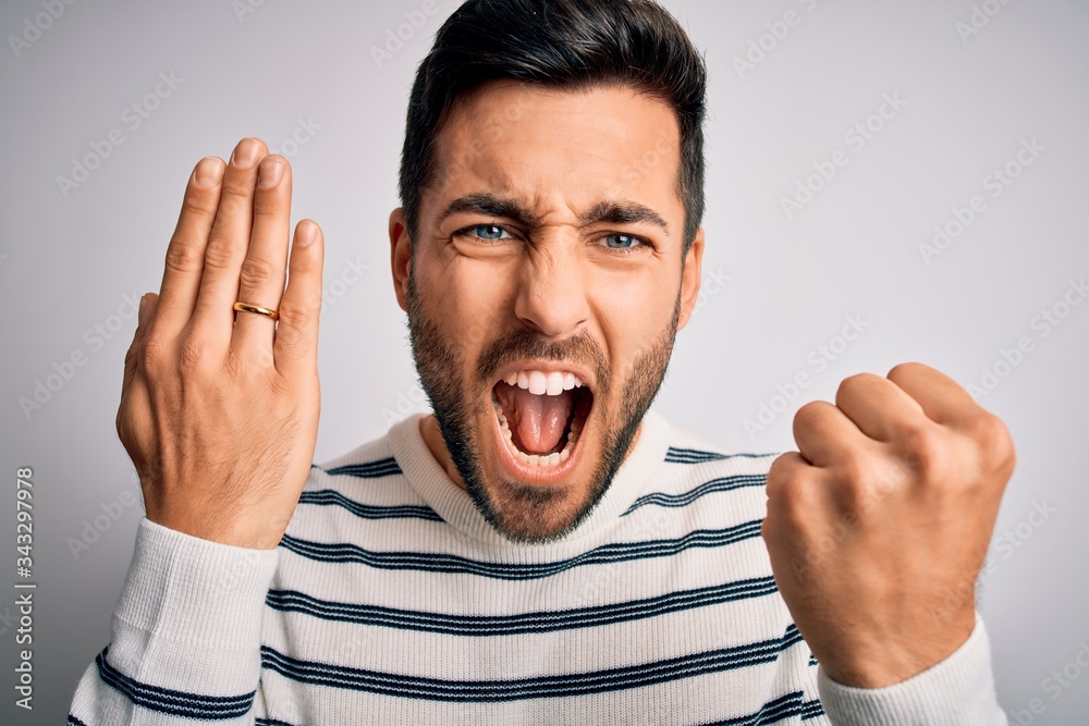 Handsome man with beard showing alliance ring marriage on finger over white background annoyed and frustrated shouting with anger, crazy and yelling with raised hand, anger concept Handsome man with beard showing alliance ring marriage on finger over white background annoyed and frustrated shouting with anger, crazy and yelling with raised hand, anger concept