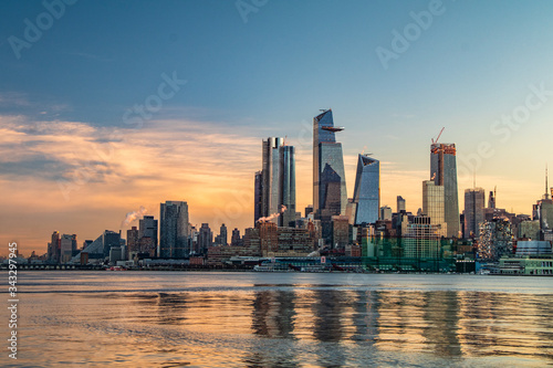 Cityscape of a sunrise over Manhattan s west side from across the Hudson River