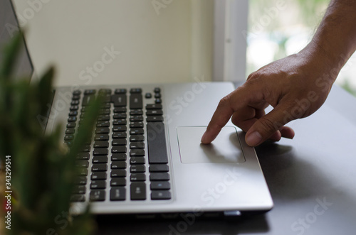 Close up of a .hands business person using a laptop computer to work at home