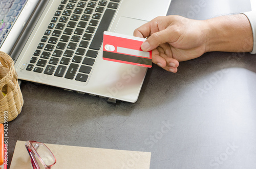 Close up of.the hand of a business person using credit card and laptop computer during work at home